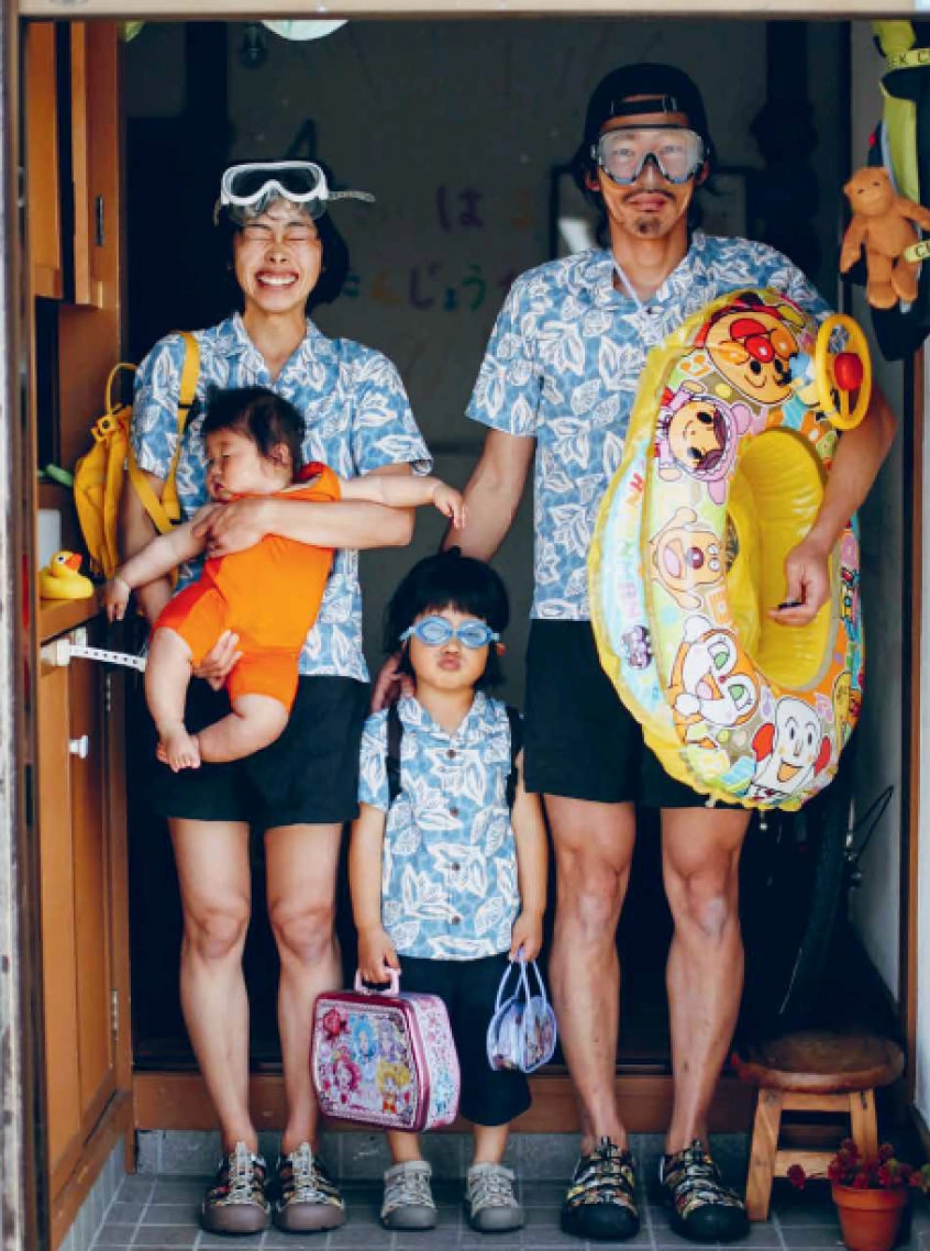 Parents with two young children wearing goggles, Hawaiian shirts, and Newport sandals in a doorway